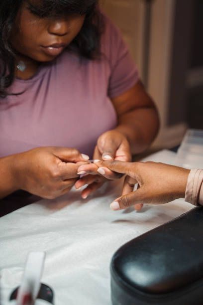 Nail technician working with a customer